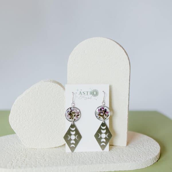 Bitter Dogbane With Moon Phases by Astro & Sol - Pressed flower earrings featuring genuine dogbane blooms in pink and coral hues preserved in resin with elegant moon phase designs on silver-toned settings.